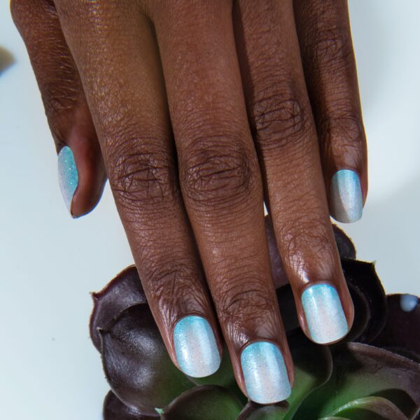 Light blue and white ombre nail polish on a model with dark skin.